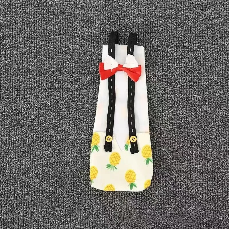 Banana Ducks Duck Diaper with suspenders, pineapple decoration and a bow tie on a textured gray surface.